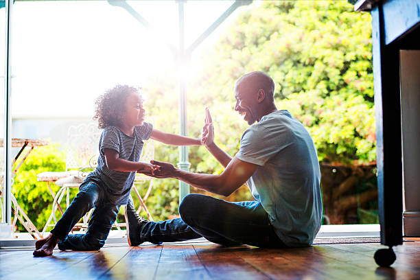 Happy father and son playing on floor at home