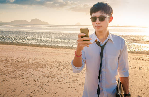 istock Business man working with laptop and smartphone beach background 516180250
