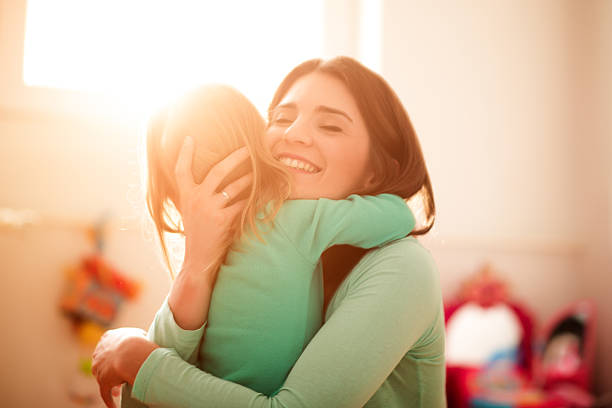 Mother and daughter hugging stock photo