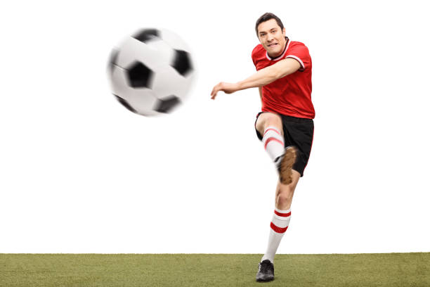 istock Football player kicking a ball on grass 516182740