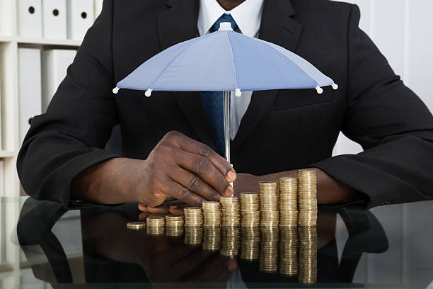 homme d'affaires avec parapluie protection de pièces - umbrella protection savings currency photos et images de collection