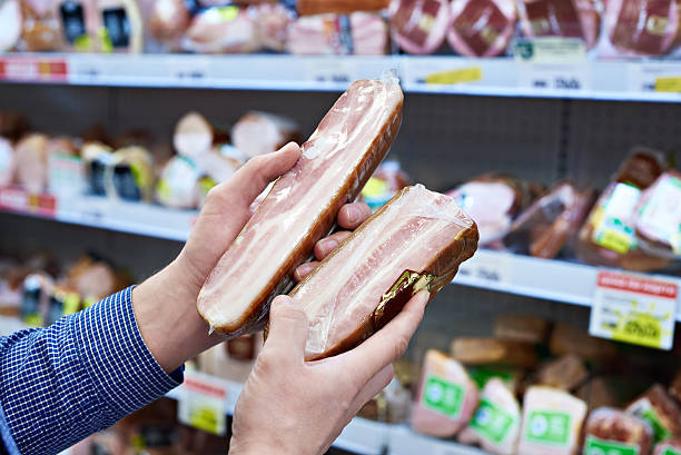 istock Buyer chooses cooked ham in shop 516186034