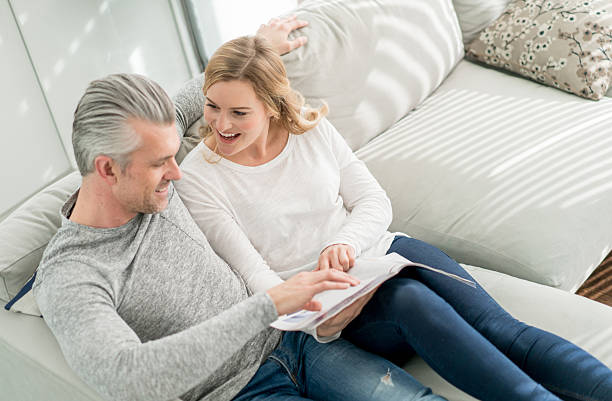 istock Couple reading a magazine at home 516186962