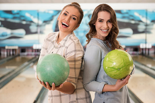 weibliche freunde in bowling-club - bowling holding bowling ball hobbies stock-fotos und bilder