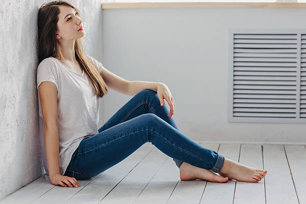 istock Beautiful girl sitting on the floor 516187726