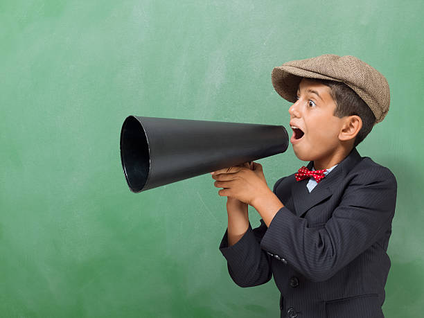 istock Little boy Shouting With Megaphone in front of blackboard 516190153