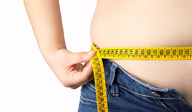 istock woman measuring her waist 516193315