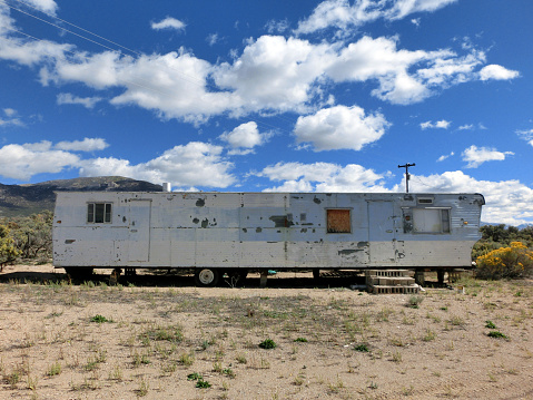 Abandoned old mobile home RV trailer in desert - landscape color photo