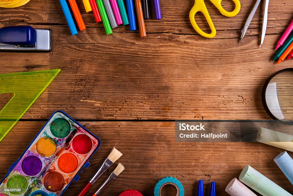 Desk with school supplies against wooden background, copy space Desk with various school supplies. Studio shot on wooden background, frame composition, empty copy space Table Stock Photo