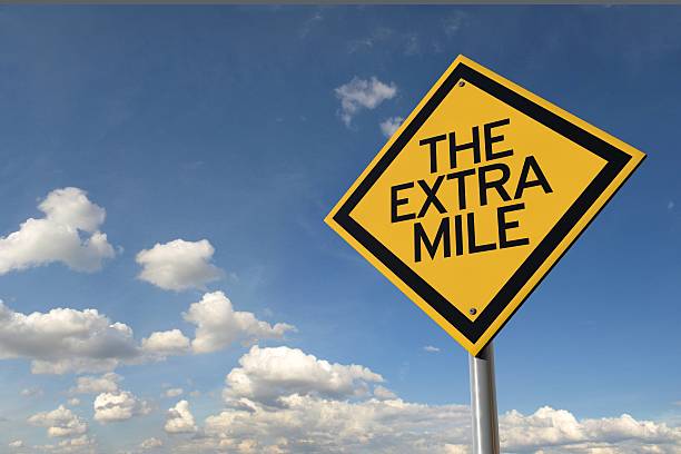 The extra mile yellow highway road sign stock photo