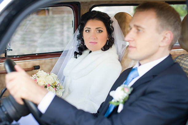 istock Young couple sitting  inside retro car 516208688
