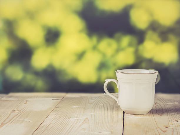 istock Vintage cup on wood table; vintage color filtered 516208922