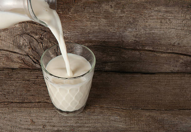 istock pouring milk from a carafe into the glass 516209728