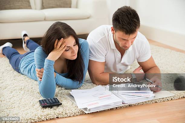 Worried Young Couple Calculating Their Bills At Home Stock Photo - Download Image Now