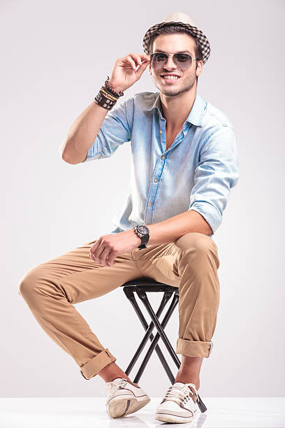 istock Smiling fashion man fixing his sunglasses while sitting 516210660