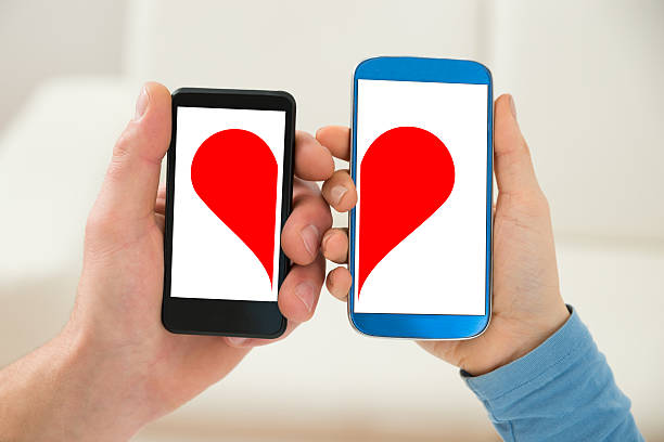 istock Couple Holding Cellphone With Half Heart Symbol 516210934