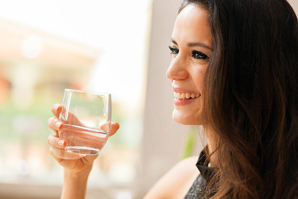 istock Beautiful young lady drinking water in restaurant 516211206