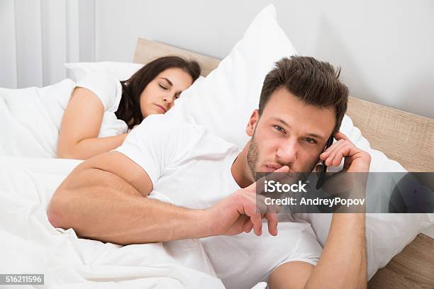 Man Talking Privately On Cellphone Stock Photo - Download Image Now - Infidelity, Men, Dishonesty