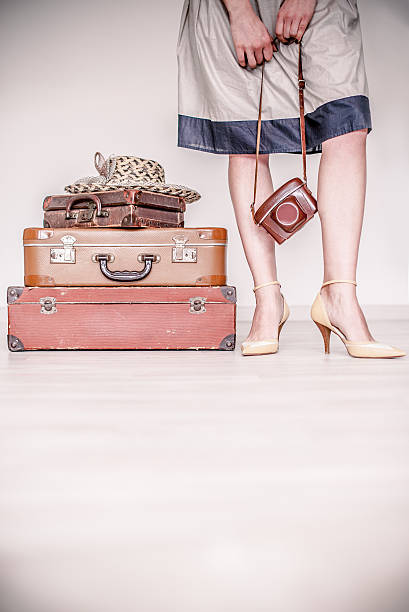 istock Woman stands beside a suitcase 516211740