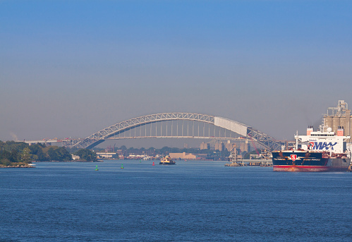 New York, NY, USA - August 25, 2014: The Bayonne Bridge in the morning. The Bayonne Bridge is the fifth-longest steel arch bridge in the world which is spanning the Kill Van Kull and connects Bayonne, New Jersey with Staten Island, New York. The bridge was designed by Othmar Ammann and the architect Cass Gilbert and opened in 1931. The bridge became a National Historic Civil Engineering Landmark in 1985.