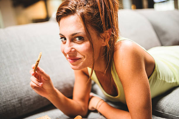 woman eating biscuit and relaxing on the couch