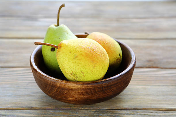 istock fresh pear in wooden bowl 516215183