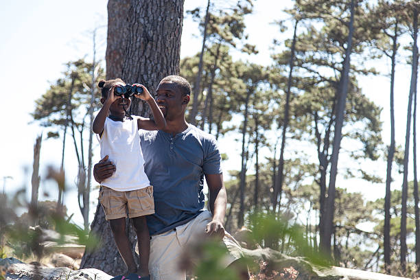 istock African father holding his daughter on the log 516215885
