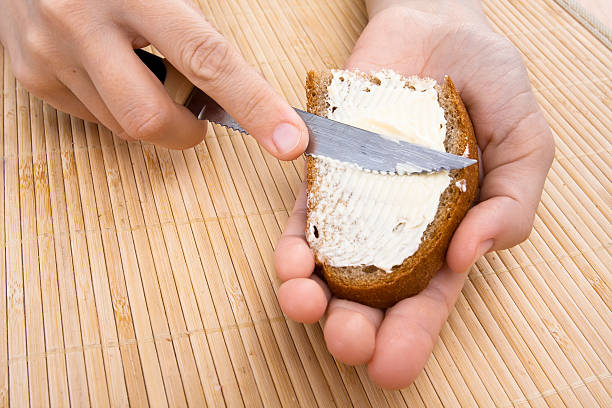 istock hands spreading butter on piece of bread 516215922
