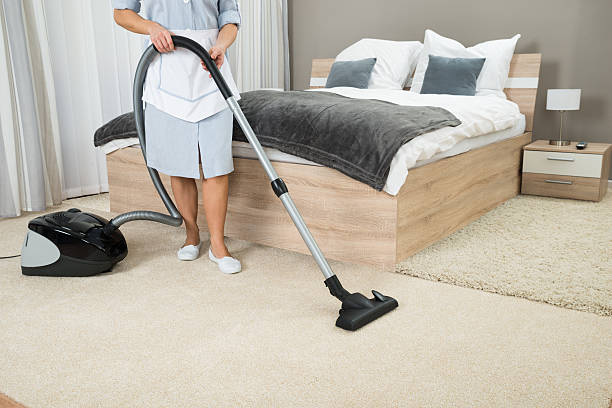 istock Female Housekeeper Cleaning With Vacuum Cleaner 516216962