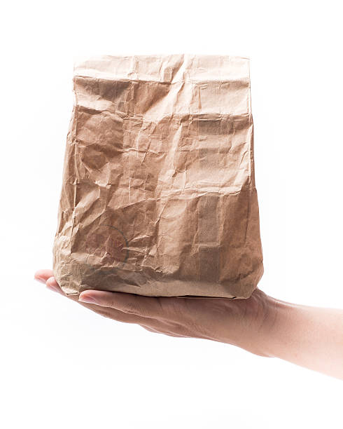 istock Brown Paper Bag on hand Isolated White Background 516218837