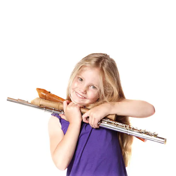 little girl in purple dress with flute and recorders before white background