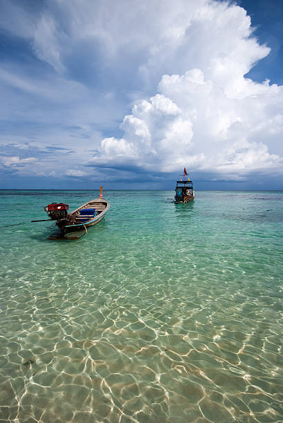 istock thai long-tailed boats with cloudy sky 516219173
