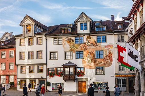 St Gallen, Switzerland - September 28, 2014: Tourists stroll in Gallusplatz, in the centre of St. Gallen. The well maintained old town is rich in half-timbered houses, palaces with frescoes and bay windows. The main tourist attraction is the Abbey of Saint Gall, a UNESCO World Heritage Site. 
