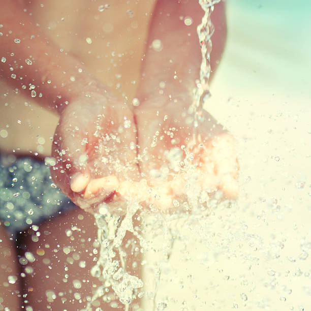 istock Stream of clean water pouring into children's hands. 516219879