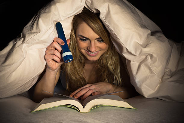istock Woman Reading Book Holding Torch 516220044