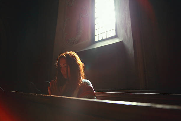 junge frau beten in der kirche - church indoors inside of monastery stock-fotos und bilder