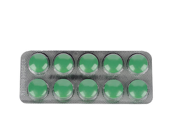 istock Green pills in blisters on white background 516234163