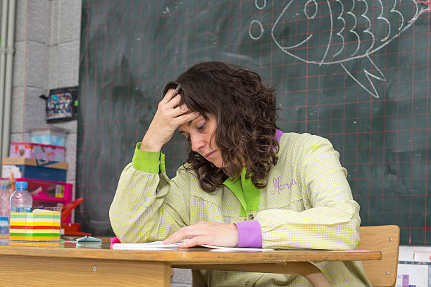 Tired teacher in classroom Tired and stressed teacher in classroom Tensed stock pictures, royalty-free photos & images