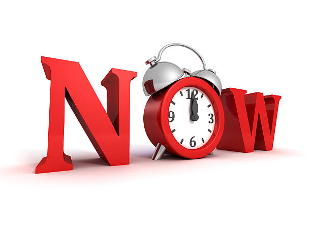 istock now red word and alarm clock on white 516235193