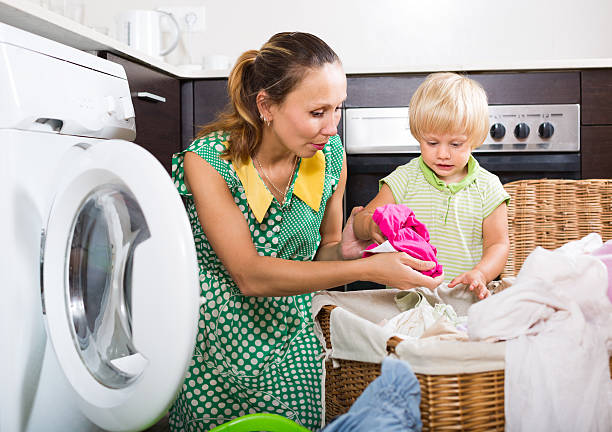 istock Woman with child near washing machine 516236189