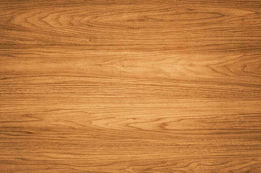 High quality brown wooden background. This background features a distinguished wood grain pattern complete with wavy lines. The colour of the wood appears darker near the left and right edges, but becomes lighter near the middle.