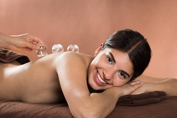 улыбается женщина, получающих банки терапии - acupuncture cupping стоковые фото и изображения