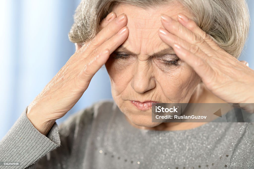 Depressed elderly woman Portrait of depressed elderly woman on blue background Adult Stock Photo