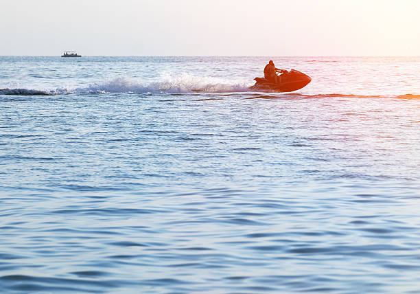istock Silhouettes of people in motion on jetski 516241914