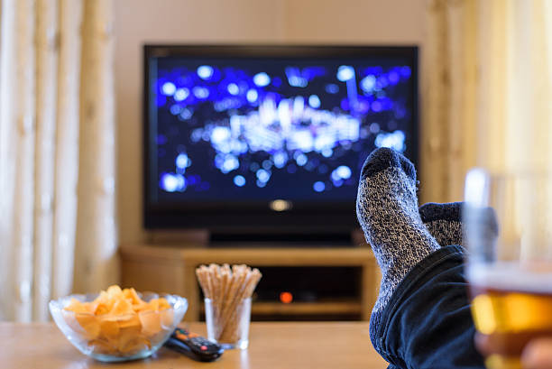istock Television, TV watching (boxing match) with feet on table 516246354