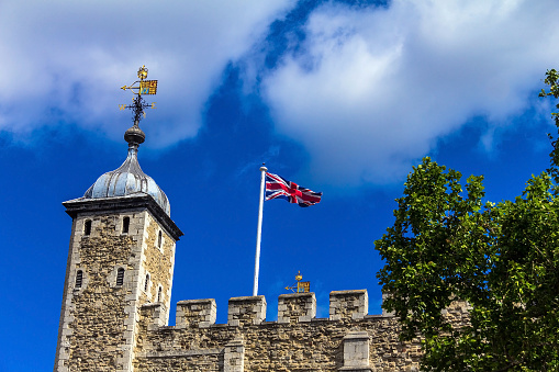 London, UK - June 6, 2015: Historic The White Tower at Tower of London historic castle with flag on the top on blue sky background