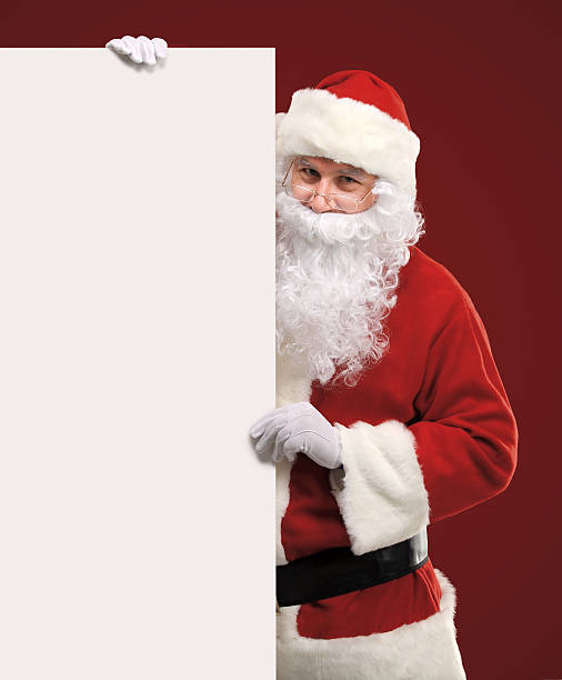 istock Santa Claus looking out from behind the blank sign 516248341
