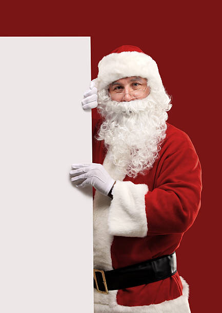 istock Santa Claus looking out from behind the blank sign 516248347