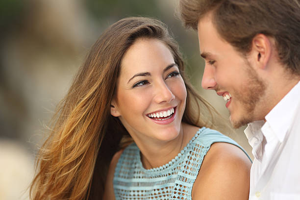 divertida pareja riendo con una sonrisa perfecta blanca - teenager beautiful female men fotografías e imágenes de stock