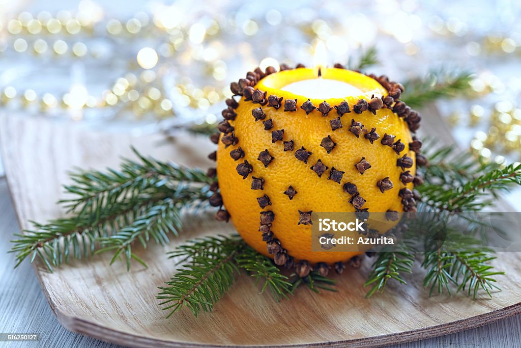 Aromatic Christmas orange with candle Aromatic Christmas orange with cloves and candle Candle Stock Photo